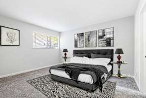 A bedroom with a large bed and two lamps.