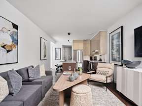 A modern living room with a grey sofa and a wooden coffee table.