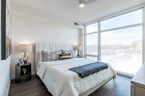 A bedroom with a large bed and a view of the city.