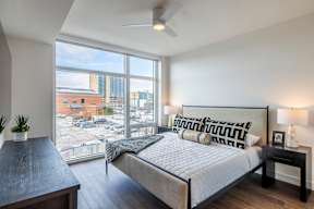 A bedroom with a large bed and a view of the city.