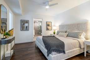 A bedroom with a large bed and a mirror on the wall.