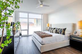 A bedroom with a large bed and a ceiling fan.