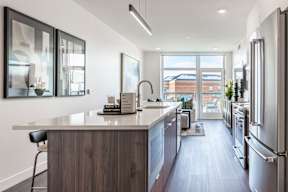 A modern kitchen with a wooden island and stainless steel appliances.