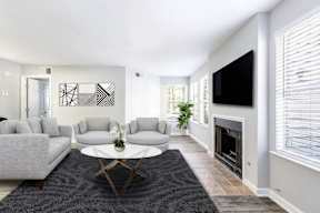A living room with a grey sofa, a white coffee table, and a fireplace.