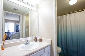 A bathroom with a white sink and a blue shower curtain.