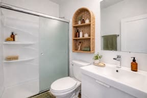 A bathroom with a toilet, sink, and shower.