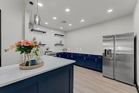 A kitchen with a white counter and a vase of flowers on it.