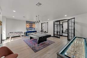 A room with a pool table and a foosball table.