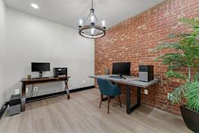 A room with a desk, chair, and computer setup.