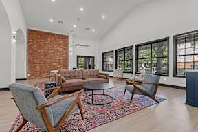 A living room with a brick wall and a couch.
