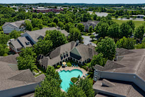 A bird's eye view of a residential area with houses and a swimming pool.