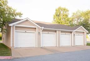 A two-car garage with a brown roof and white doors.