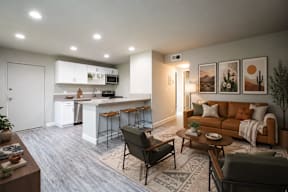 A modern living room with a kitchen in the background.