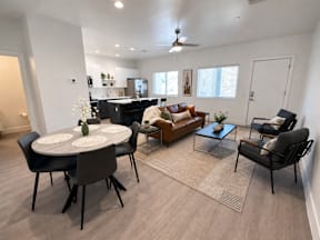 A modern living room with a dining table and chairs.