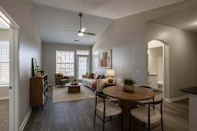 A living room with a couch, a coffee table, and a ceiling fan.