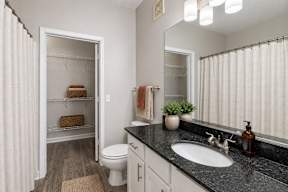 A bathroom with a white toilet, a sink, and a mirror.