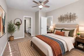 A bedroom with a large bed and a ceiling fan.