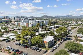 A parking lot with cars and a mountain range in the background.