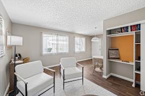 A living room with two chairs and a bookshelf.