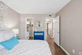 A bedroom with a white bed and blue pillow.