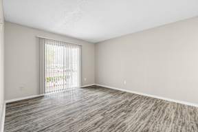 A room with wooden flooring and a sliding glass door.