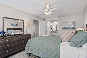 A bedroom with a bed, dresser, and mirror.
