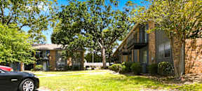 A black car is parked in front of a house.