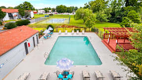 A large swimming pool surrounded by lounge chairs and umbrellas.