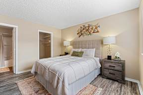 A bedroom with a large bed and a wooden dresser.
