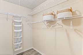 A white shelf with two baskets and a white container on it.