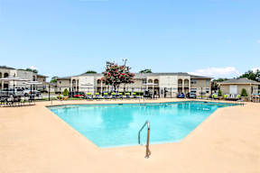 A swimming pool in a residential area with a sandy bottom.