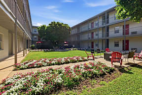 A sunny day at a residential complex with a well-maintained garden in the foreground.