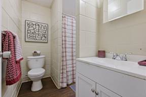 A bathroom with a toilet, sink, and shower.