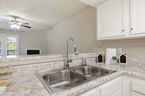 A kitchen with a sink and a fan.