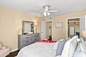 A bedroom with a bed, dresser, and mirror.
