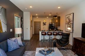 A modern living room with a grey couch and a black chair.