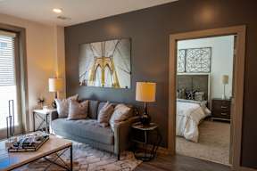 A living room with a grey couch, a coffee table, and two lamps.