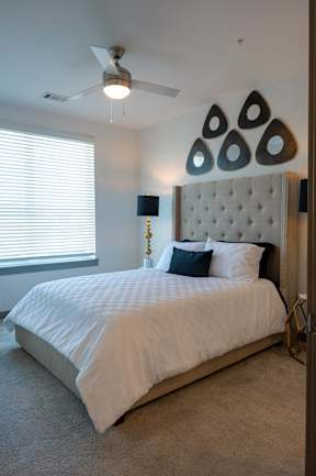 A bedroom with a large bed and a ceiling fan.