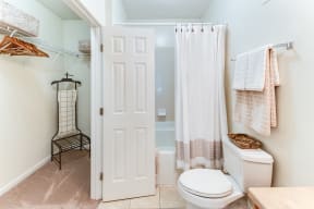 a bathroom with a white toilet and a white shower curtain