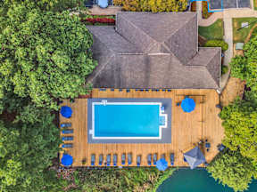 a backyard with a pool and deck with umbrellas