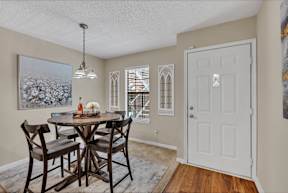 a dining room with a table and chairs and a white door