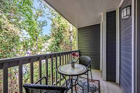 a patio with two chairs and a table on a balcony