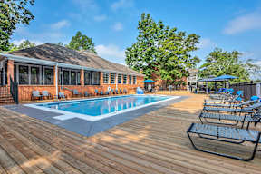 a swimming pool with chairs around it outside of a building