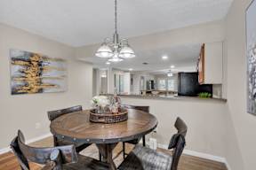 A dining room with a wooden table and chairs.