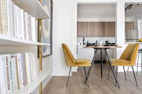 a dining room with a table and chairs and a book shelf