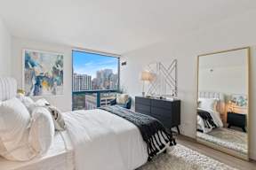 a bedroom with a bed and a large window