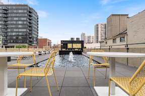 a roof terrace with tables and chairs and a fountain