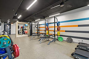 a gym with weights and a wall painted with a subway train