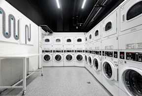 a row of washers and dryers in a laundry room
