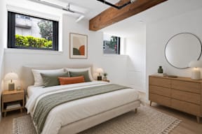A bedroom with a bed, nightstands, and a painting on the wall.